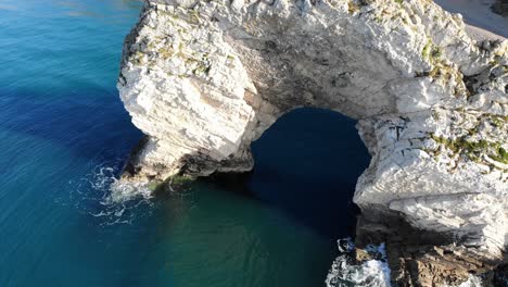 Aerial-Over-Limestone-Durdle-Door-Arch-Surrounded-By-Calm-Turquoise-Waters