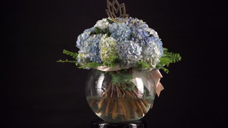 Nelke-Blumenarrangement-Chrysantheme-Mit-Band-Im-Wassertank,-Der-Sich-Auf-Schwarzem-Hintergrund-Dreht