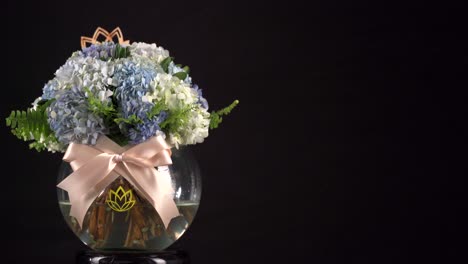Carnation-water-tank-floral-arrangement-with-ribbon-slider-shot-on-black-background