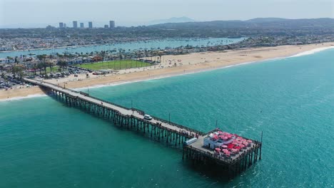 Rotating-aerial-view-of-the-Balboa-pier-and-Rubies-diner-in-Newport-Beach,-California