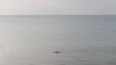 Wide-view-of-sea-with-single-person-canoeing-along-the-sea