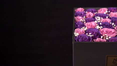 Pink-and-purple-roses-in-present-box-slider-shot-in-black-background