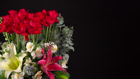 Bouquet-Flowers-arrangement-slider-shot-in-black-background-roses-orchis-lilies