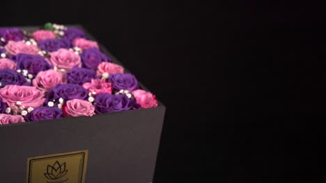 Pink-and-purple-roses-in-present-gift-box-slider-shot-in-black-background