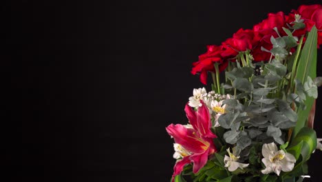Flowers-arrangement-spinning-in-black-background-slider-shot-roses-lilies-orchids