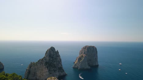 Aerial---Faraglioni-rock-stacks-off-of-Capri-island,-Tyrrhenian-Sea,-Italy