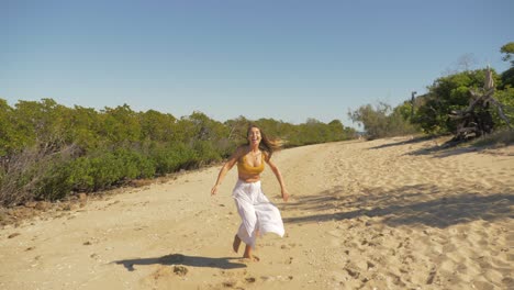 Weiblicher-Tourist,-Der-Auf-Dem-Sand-Mit-Dichtem-Laub-In-Langford-Island,-Whitsundays,-Queensland-Läuft