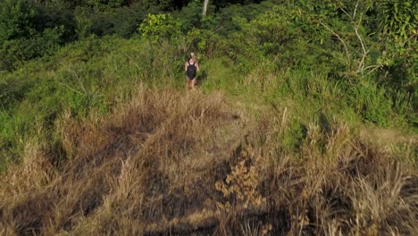 Woman-on-adventure-hiking-through-tropical-jungle-on-Cebu-island,-aerial