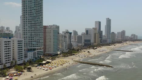 Fixed-Aerial-Shot-of-Waves-Crashing-on-Playa-Bocagrande-in-Cartagena,-Colombia
