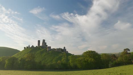 Panning-shot-of-Corfe-Castle-and-surrounding-Purbeck-hills-in-the-early-morning-light