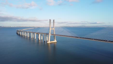 AERIAL-Approaching-Shot-of-the-Huge-Vasco-da-Gama-Bridge-in-Lisbon,-Portugal