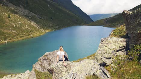 Young-woman-enjoying-the-mountain-lake-view-in-the-austrian-alps-with-amazing-colerfull-landscape