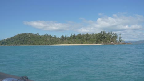 View-From-A-Sailing-Boat-Of-Lush-Green-Hamilton-Island-Covered-In-Bushland-And-Surrounded-By-Calm-Blue-Sea-In-Whitsundays,-Queensland,-Australia