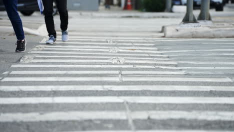 Pedestrians-crossing-a-street-by-the-crosswalk-of-a-big-city-in-daylight-filmed-in-super-slow-motion-in-4K-high-definition