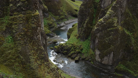 Dramatic-tilt-up-to-reveal-shot-of-the-super-cinematic-Fjadrarglijufur-canyon-Iceland