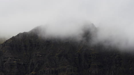 Cinematic-dolly-in-towards-cloud-covered-mountain-peaks-in-the-rugged-terrain-of-Fjallsárlón-Iceland