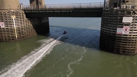 People-Riding-Jet-Skis-Under-Kingsferry-Bridge-In-England---aerial-shot