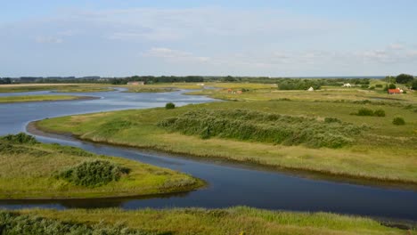 Aerial-low-altitude-pass-over-the-canals-and-meadows-of-Waterdunes---a-nature-area-and-recreational-park-in-the-province-of-Zeeland,-The-Netherlands
