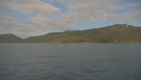 Rippling-Waters-Of-Hook-Passage-In-Whitsunday-Area,-Queensland-With-Dense-Vegetation-On-Rugged-Inlet-In-Background