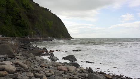Frothy-waves-crash-agianst-the-rocky-beach-and-sea-defences-in-Lynmouth-on-a-very-windy-day