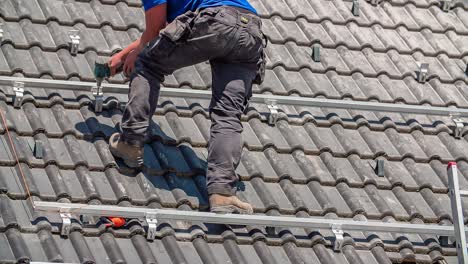 Close-up-shot-of-male-worker-preparing-industrial-construction-on-rooftop-with-drill-for-solar-panels