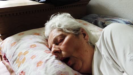 Müde-ältere-Frau,-Die-Im-Bett-Schläft---Handgehaltener-Stetiger-Schuss