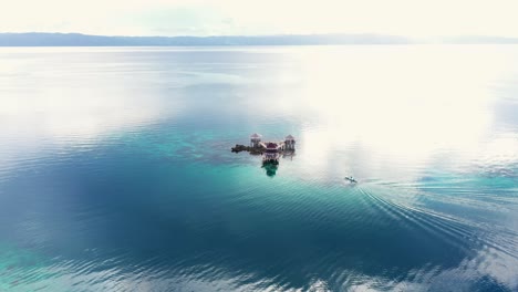Vista-Lejana-De-Un-Barco-Que-Se-Acerca-A-La-Cabaña-De-Agua-En-El-Parque-Marino-Tagbak-En-El-Sur-De-Leyte,-Filipinas