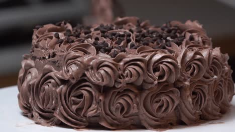chocalate-cake-on-turn-table-with-icing-of-flower-desing