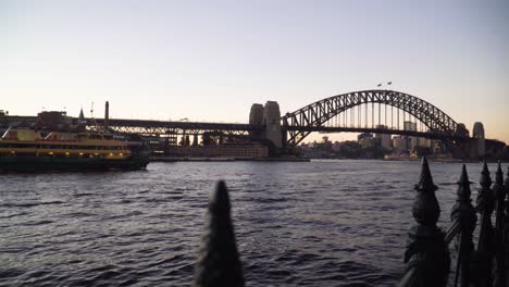 Ferryboat-Sailing-Towards-Sydney-Harbour-Bridge-At-Sunset-In-Sydney,-NSW,-Australia