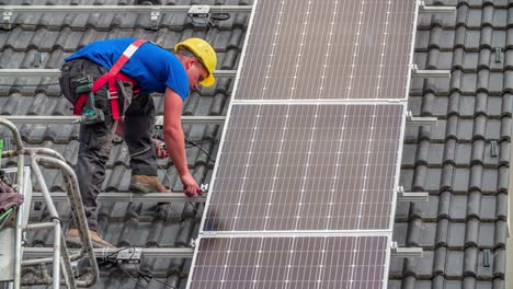 Male-Worker-Perform-Solar-Panel-Installation-on-Rooftop-of-House-in-Summer-in-Slow-Motion