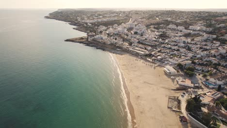 Warm-sunny-Algarve-Beach-Praia-da-Luz-shoreline---Aerial-fly-over