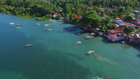 Luftaufnahme-Von-Booten,-Die-Auf-Dem-Blauen-Meer-In-Der-Nähe-Des-Fischerdorfes-In-Southern-Leyte,-Philippinen,-Verankert-Sind