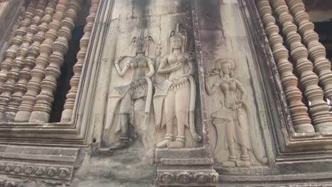 Langsamer-Schwenk-Um-Die-Detailreiche-Fassade-Einer-Tempelgalerie-In-Angkor-Wat,-Kambodscha,-Mit-Drei-Frauen