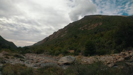Water-flows-over-the-Casa-de-Piedra-stream,-under-a-cloudy-sky,-on-the-way-to-the-general-San-Martin-refuge-in-San-Carlos-de-Bariloche,-Argentina