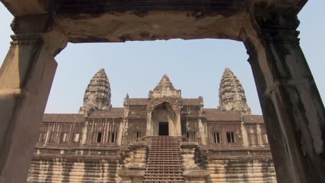 Slowly-moving-shot-through-an-ancient-gate-way-towards-the-temple-of-Angkor-Wat-in-Cambodia