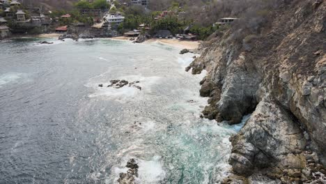 Pull-front-next-to-cliff-with-view-of-small-beach-in-Oaxaca,-Mexico
