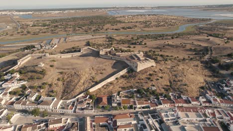 Panning-aerial-landscape-of-São-Sebastião-de-Castro-Marim-fortress-with-vast-expense-of-salt-marsh