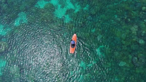 Bird's-Eye-View-Of-The-Man-Rowing-On-A-Paddle-Board-At-The-Clear-Waterscape-Of-Tagbak-Marine-Park