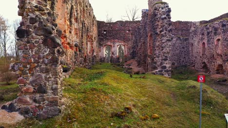 Interior-of-medieval-castle-remains,-drone-fly-forward-in-low-altitude