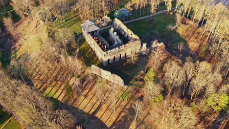 Remains-of-stone-medieval-castle-surrounded-by-forest-and-small-town