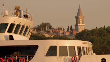 Close-telephoto-clip-of-upper-decks-of-Istanbul-ferry-as-it-passes-Topkapi-Palace-at-sunset