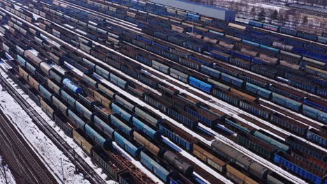 Vast-rows-of-rolling-stock-wait-in-the-train-yard-near-Katowice-Poland---Aerial-drone-tracking-shot-left-to-right---Snow-covered-winter-industrial-landscape
