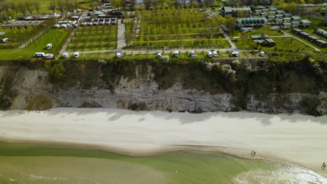 Drone-flying-towards-the-campsite-with-numerous-camper-trailers-on-the-cliff-near-Baltic-sea-and-Chlapowo-village-beach-near-Władysławowo-town
