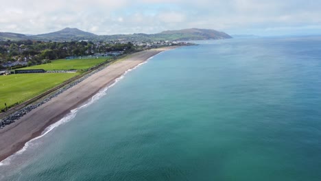 Aerial-footage-of-beach,-coastline-and-sea-while-flying-along-the-coast