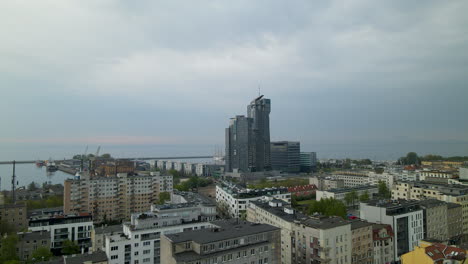 Aerial-flyover-Gdynia-Cityscape,port-and-Sea-tower-in-front-of-Baltic-Sea-during-cloudy-day