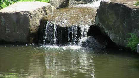 Wasser-Fließt-Felsen-Hinab-In-Den-Teich