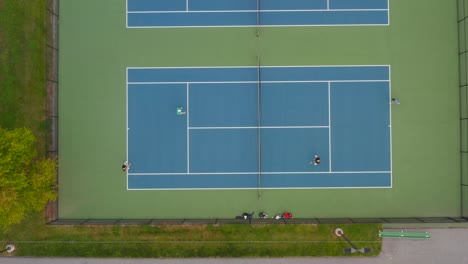 Top-down-aerial-of-doubles-playing-tennis-at-court