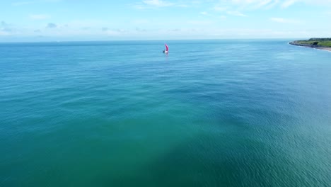 Luftverfolgung-Eines-Segelbootes-Entlang-Einer-Küste-An-Bewölkten-Tagen-Mit-Unterschiedlichem-Sonnenlicht