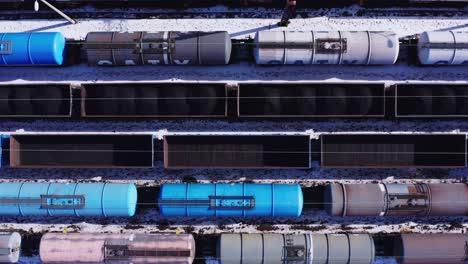 Birdseye-drone-view-of-empty-rail-tankers-and-freight-cars---Katowice-Poland-railway-yard---Winter-industrial-landscape-with-snow
