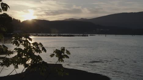 Sonnenuntergang-Hinter-Bergen-Und-Pier-Im-Hafen-Stimmungsvoll---Zeitraffer